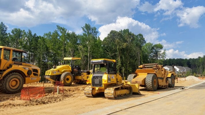 Bulldozers cutting down trees behind the lot